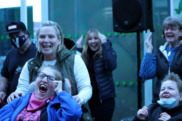 People sing and smile for Saturday shoppers in the entrance to the store