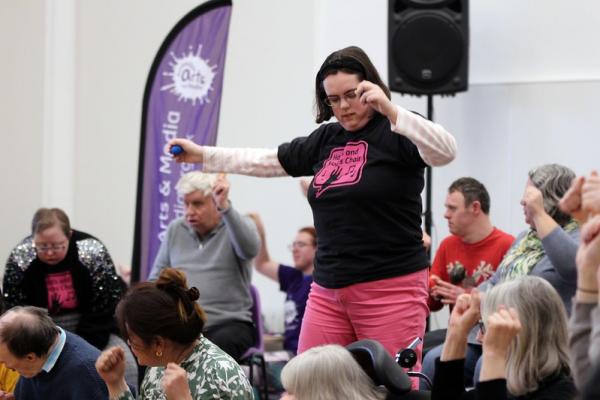 A member of Movers & Shakers dances on stage surrounded by other members