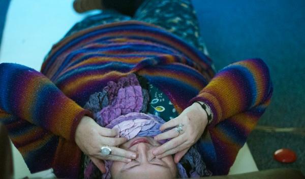 Participant lays down with their hands on their eyes during an iMUSE session