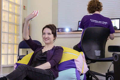 A person sits with their hand in their air as they control the iMUSE kit