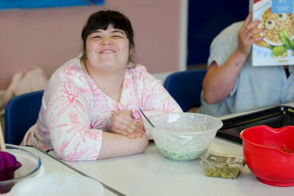 Participant smiling with a bowl of ingredients in a session