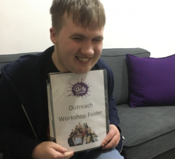 IMPs trainee poses with his Outreach workshop hand book. 