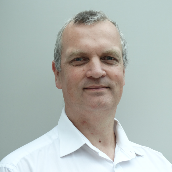 Mike Cross stands against a grey background