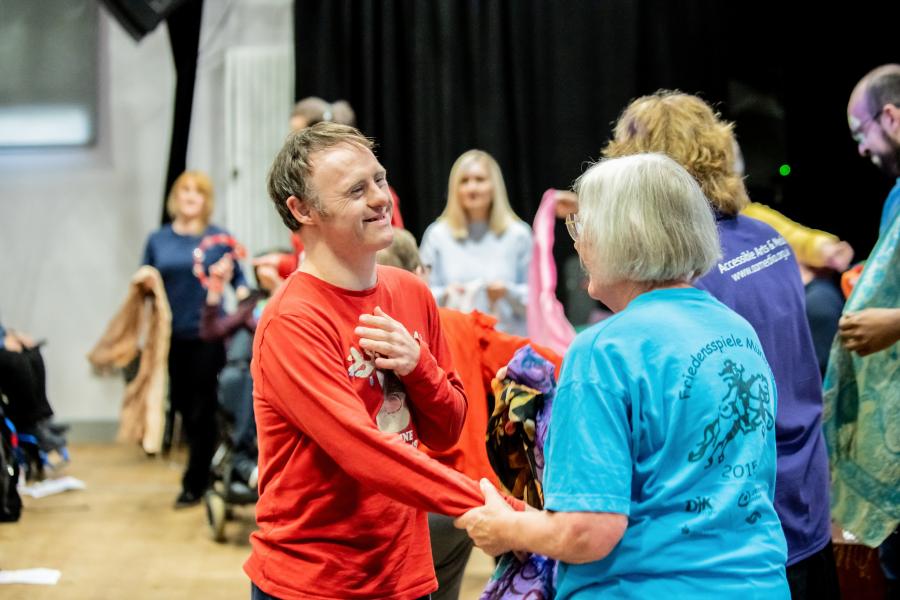 Participants and a facilitator dancing together at an AAM event